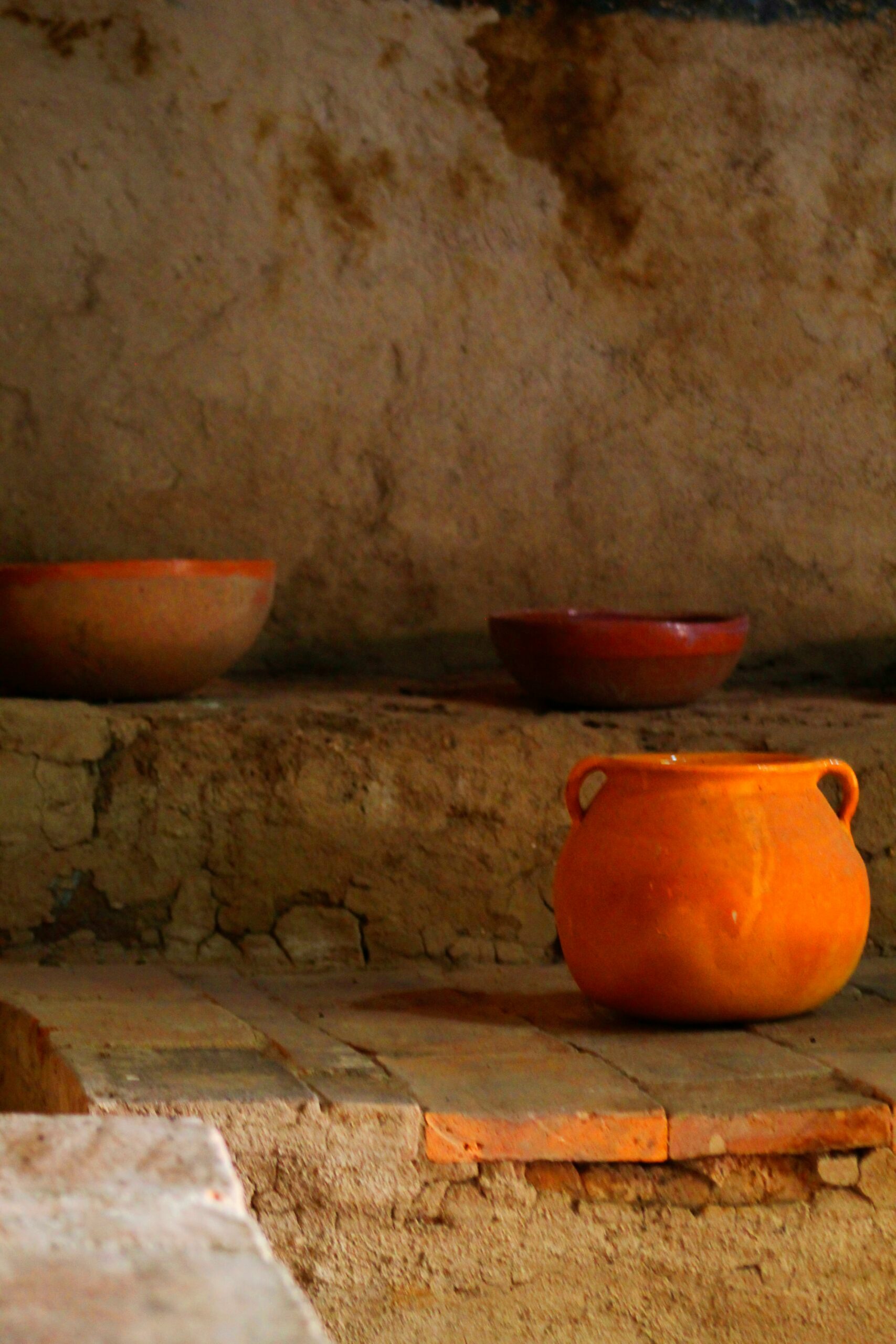 Terracotta pots on a rustic shelf, illustrating a method to save water for tomato plants.