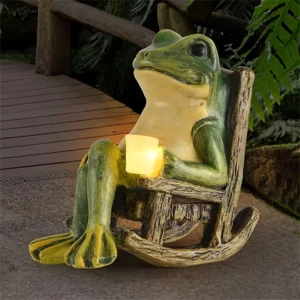 Frog statue in a rocking chair holding a glowing light. Garden decor.
